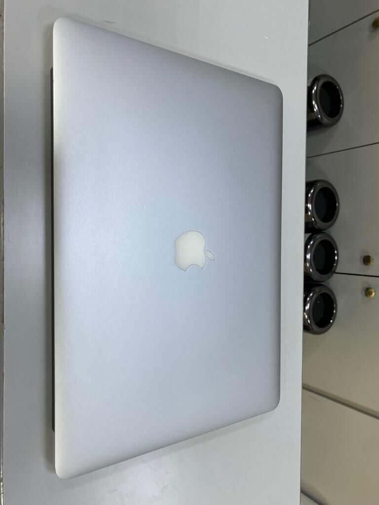 Silver Apple MacBook Air A1466 (2015) closed on a desk, featuring a sleek design.